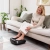 HoMedics Foot Flow PSL-2000 – masażer do stóp i łydek w użyciu przy sofie, zbliżenie stóp